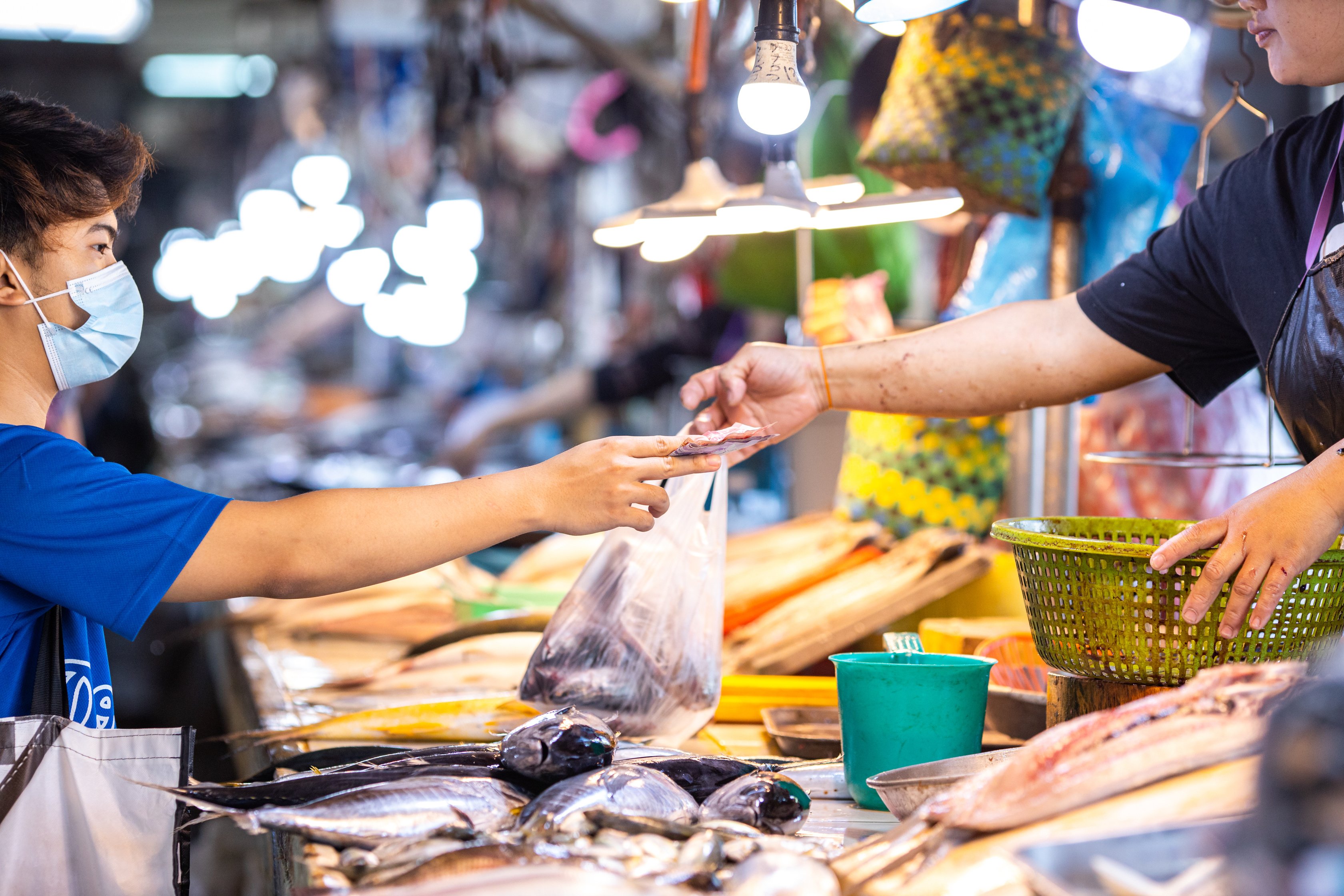 Customer Buying Fresh Fish from Vendor in the Wet Market