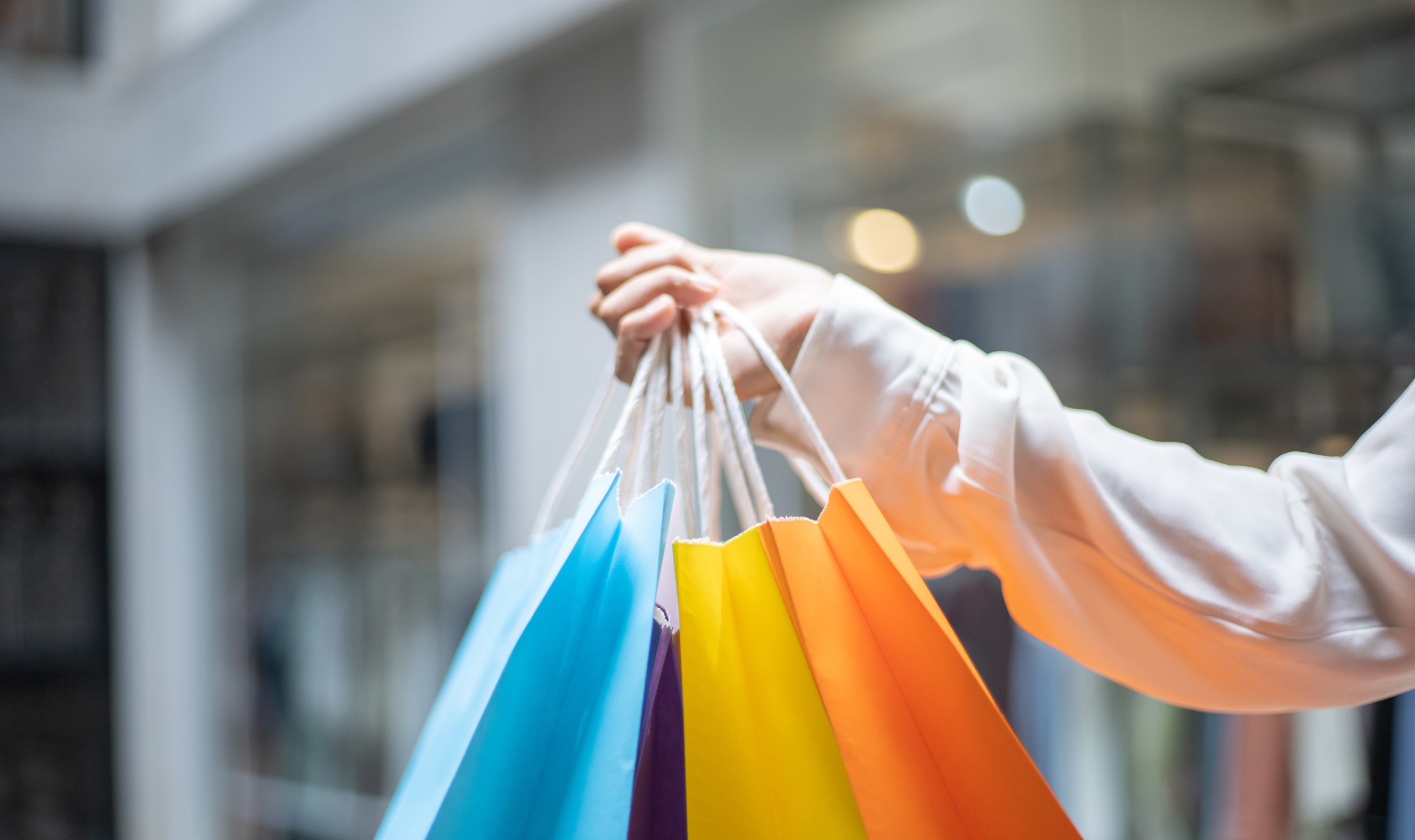 Hand Holding Colorful Shopping Bags 